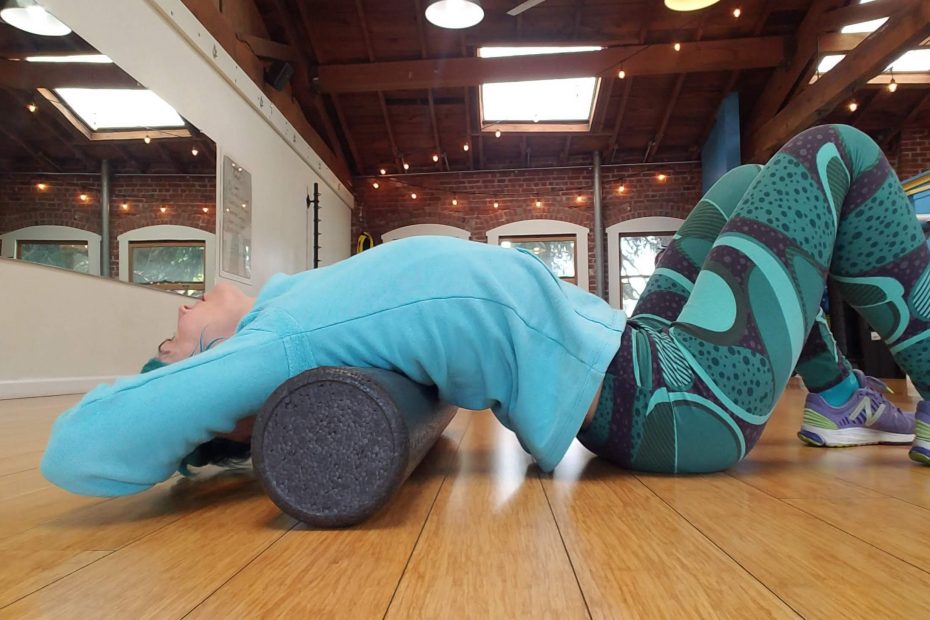 Woman arched over foam roller